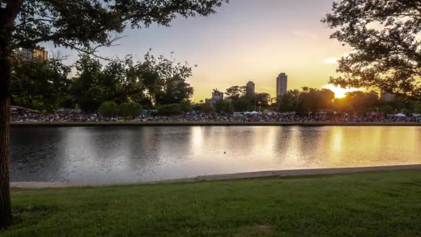 Chicago, IL - 20 de julio de 2019: Multitudes se reúnen a través de la laguna sur en Lincoln Park para el primer festival de linternas de agua con comida y música mientras el sol se pone debajo del horizonte . — Vídeos de Stock