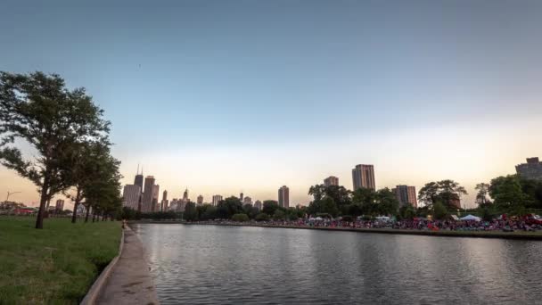 Chicago, IL - 20 de julho de 2019: multidões começam a se reunir para o primeiro festival de lanternas de água de Chicago na lagoa sul no Lincoln Park no sábado com o belo cenário do horizonte da cidade . — Vídeo de Stock