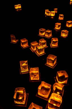 Chicago, Il - 20 Temmuz 2019: Lincoln Park'taki Water Lantern Festivali'nde Cumartesi akşamı müzik, yemek ve aile dostu etkinliklerle parlayan turuncu fenerler Güney Lagünü boyunca süzülüyor.