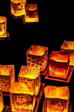 Chicago, Il - 20 Temmuz 2019: Lincoln Park'taki Water Lantern Festivali'nde Cumartesi akşamı müzik, yemek ve aile dostu etkinliklerle parlayan turuncu fenerler Güney Lagünü boyunca süzülüyor.