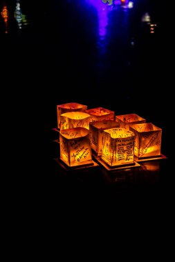 Chicago, Il - 20 Temmuz 2019: Lincoln Park'taki Water Lantern Festivali'nde Cumartesi akşamı müzik, yemek ve aile dostu etkinliklerle parlayan turuncu fenerler Güney Lagünü boyunca süzülüyor.