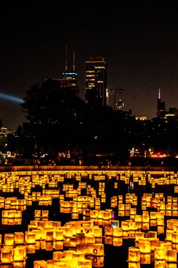Chicago, Il - 20 Temmuz 2019: Lincoln Park Cumartesi günü Su Fener festivalinde lagün boyunca parlayan fenerler gıda, müzik ve eğlence bir gece için fon olarak şehir silueti ile yüzer.