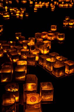 Chicago, Il - 20 Temmuz 2019: Lincoln Park'taki Water Lantern Festivali'nde Cumartesi akşamı müzik, yemek ve aile dostu etkinliklerle parlayan turuncu fenerler Güney Lagünü boyunca süzülüyor.