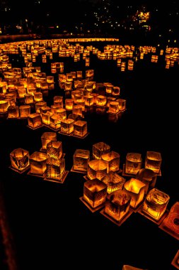 Chicago, Il - 20 Temmuz 2019: Lincoln Park'taki Water Lantern Festivali'nde Cumartesi akşamı müzik, yemek ve aile dostu etkinliklerle parlayan turuncu fenerler Güney Lagünü boyunca süzülüyor.