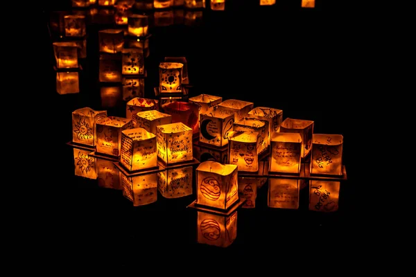 Chicago, Il - 20 Temmuz 2019: Lincoln Park'taki Water Lantern Festivali'nde Cumartesi akşamı müzik, yemek ve aile dostu etkinliklerle parlayan turuncu fenerler Güney Lagünü boyunca süzülüyor.