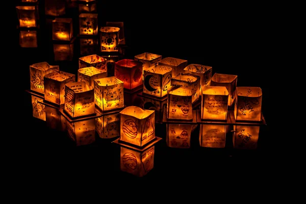 Chicago, Il - 20 Temmuz 2019: Lincoln Park'taki Water Lantern Festivali'nde Cumartesi akşamı müzik, yemek ve aile dostu etkinliklerle parlayan turuncu fenerler Güney Lagünü boyunca süzülüyor.