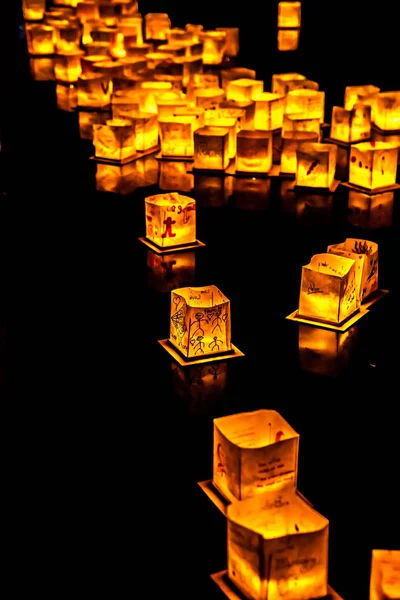 Chicago, Il - 20 Temmuz 2019: Lincoln Park'taki Water Lantern Festivali'nde Cumartesi akşamı müzik, yemek ve aile dostu etkinliklerle parlayan turuncu fenerler Güney Lagünü boyunca süzülüyor.