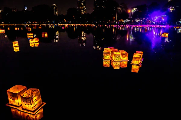 Chicago, Il - 20 Temmuz 2019: Lincoln Park'taki Water Lantern Festivali'nde Cumartesi akşamı müzik, yemek ve aile dostu etkinliklerle parlayan turuncu fenerler Güney Lagünü boyunca süzülüyor.
