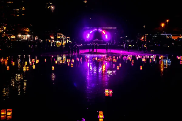 Chicago, IL - 20 de julio de 2019: Linternas naranjas brillantes flotan por la laguna sur en el Water Lantern Festival en Lincoln Park el sábado por la noche con música, comida y actividades para familias . — Foto de Stock