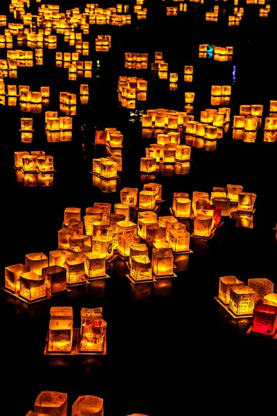 Chicago, Il - 20 Temmuz 2019: Lincoln Park'taki Water Lantern Festivali'nde Cumartesi akşamı müzik, yemek ve aile dostu etkinliklerle parlayan turuncu fenerler Güney Lagünü boyunca süzülüyor.