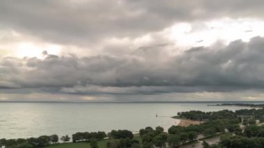 Araç ve araba Chicago'da Lake Shore Drive aşağıda geçmek gibi fırtına bulutları ve Foster Beach yakınlarındaki Michigan Gölü üzerinde haddeleme yağmur zaman atlamalı havadan görünümü.