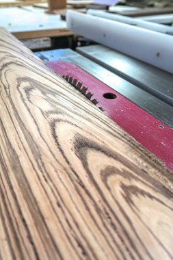 Endüstriyel bir masada oturan bir levha veya zebrawood tahta parçası yakın bir bakış açısı bıçak kaldırdı ile bir ahşap atölyesinde gördüm.