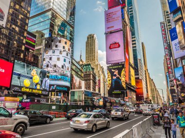 New York, New York - 19 Mayıs 2017: İnsanlar beton barikatlarla korunan kaldırımda geçerken Times Meydanı'nın merkezindeki kalabalık caddelerden trafik geçiyor.