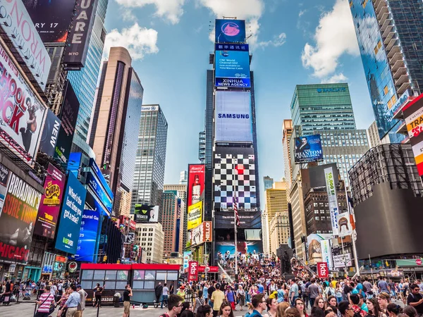 stock image New York City, New York - May 19th, 2017: Tourists and pedestrians explore the iconic Times Square and take in the colorful sites and lighted advertisements and highrise buildings around the plaza.