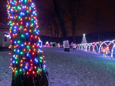 Çok renkli Led Noel dize ışıkları bir tatil ışıkları festival ekranda arka planda kemerli yürüyüş yolları ile bir ağacın gövdesi sarın.