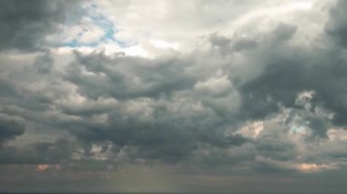 Güneş batmadan hemen önce Michigan Gölü 'nün suları üzerinde bulutlu bulutlu gökyüzünü büyüten fırtına mavi gökyüzünde turuncu renkli bulutlar oluşturur..