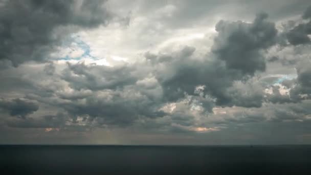 太陽が青い空にオレンジ色の雲を作り出す直前に 嵐が夕暮れ時に吹き抜けるので ミシガン湖の水の上に空中の雲のような曇り空のタイムラプス — ストック動画