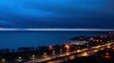 Şikago 'daki Lake Shore Drive' da gece vakti trafik ve ışık yollarını kapamak çok güzel. Michigan Gölü 'nün sakin sularında ağır bulutlar hareket ediyor..
