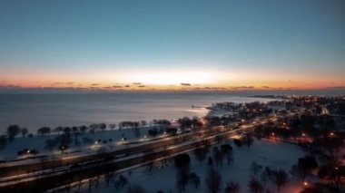 Şikago Lakefront Gölü boyunca uzanan ve güneş ufukta belirdiğinde Lake Shore Drive 'dan geçen trafik ile birlikte güzel bir dikey güneş doğumu zamanı.