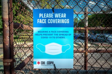 Chicago, IL - 11 Haziran 2020: Chicago Halk Sağlığı Bakanlığı tarafından asılan mavi bir tabela, COVID-19 Coronavirus 'un yayılmasını önlemek için yayalara maske taktıklarını bildirdi.