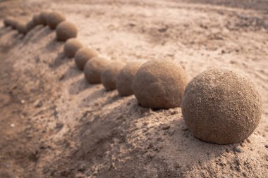 Dalgalanan kumdan kale tepesi ya da duvarın yakın görüntüsü mükemmel yuvarlak toplar ya da sırtta yukarı aşağı hareket eden ıslak kum küreleri yılan şeklinde..