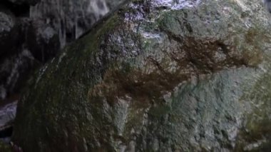Düşük görüş açısı, çağlayan şelalenin altındaki bir nehir yatağında büyük kaya kayalarının üzerinden geçen bir şelaleye doğru dönüyor..