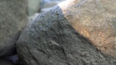 Düşük görüş açısı, çağlayan şelalenin altındaki bir nehir yatağında büyük kaya kayalarının üzerinden geçen bir şelaleye doğru dönüyor..