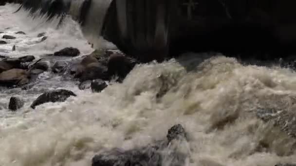 下の川にコンクリートダムを作った男の上を流れる滝の流れやカスケード水の側面のビューをパンニング — ストック動画
