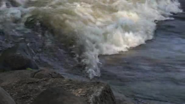 前景の岩と円で囲まれた白い水の急流の近くにあるケースイーグルパークダムバーリントン — ストック動画