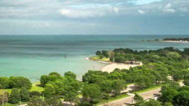 Chicago 'daki Lake Shore Drive' da trafik hızlandıkça zaman azalıyor. Michigan Gölü 'nün mavi sularına doğru ilerleyen tüylü beyaz bulutlar havada süzülüyor..