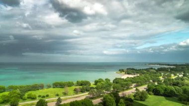 Chicago 'daki Lake Shore Drive' da trafik hızlandıkça sabit zaman azalıyor. Michigan Gölü 'nün mavi sularına doğru ilerleyen tüylü beyaz bulutlar havada süzülüyor..