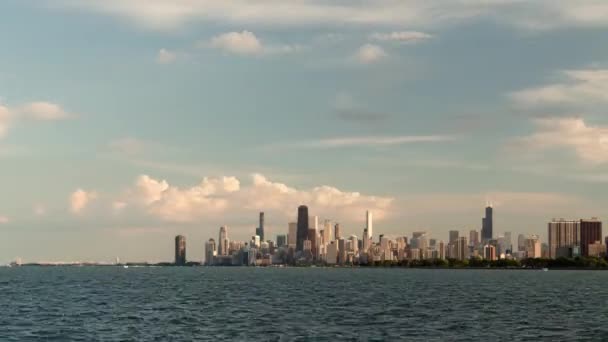 美丽的芝加哥天际线城市在夕阳西下时光流逝 帆船在蓝色的水面上穿行 密歇根湖波涛汹涌 市中心摩天大楼上空笼罩着粉色和蓝色的彩云 — 图库视频影像