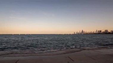 Chicago, IL - 13 Ağustos 2020: Küçük yelkenliler gün batımından önce Montrose Limanı yakınlarındaki Michigan Gölü 'nde yarışmak için toplanıyor..