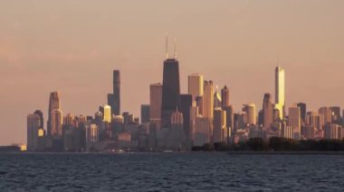 Gün batımında Chicago silueti şehir seyahati sona ererken yelkenliler mavi sularda ve Michigan Gölü 'nün dalgalarında inanılmaz gökdelenler, yüksek binalar ve şehir manzarası önünde yarışıyor..