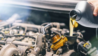 Araba motoruna yağ döküyorum. Arabadaki yağ değişimi sırasında taze motor yağı döküldü..