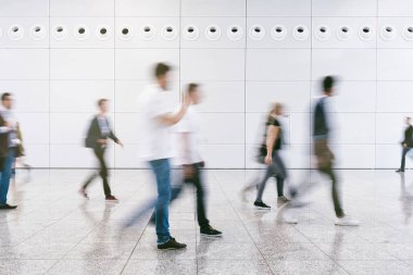 Anonim insanlardan oluşan kalabalık modern bir salonda yürüyor.