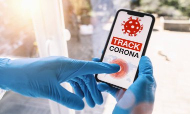 coronavirus tracker app on a mobile smartphone. Close up of woman tracking crowd of people in a smartphone screen application. Hand holding smart device. Mockup website. covid-19 corona virus tracker
