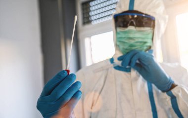 COVID-19 örnek toplama seti tutan tıbbi sağlık teknisyeni, beyaz PPE koruyucu giysi maskeli eldivenler, OP NP hasta numunesi almak için test tüpü, PCR DNA test süreci