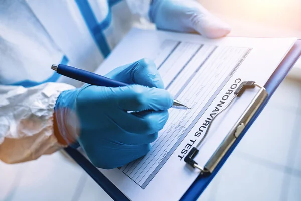 Researcher Fills Out Coronavirus Test Data Sheet Pen Protective Clothing — Stock Photo, Image