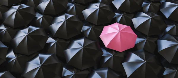Unique pink umbrella among many dark ones. Standing out from crowd, individuality and difference concept