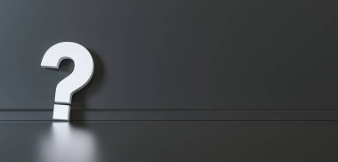 Big white question mark in front of black wall with copy space as faq concept