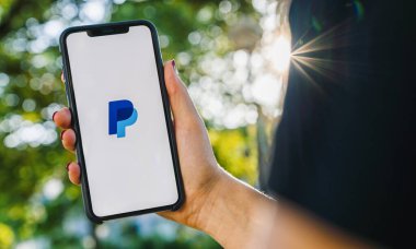 BERLİN, ALMANY AĞUSTOS 2019: Paypal uygulamasının logosu olan iPhone X 'leri tutan kadın. Paypal web sitesi internet üzerinden para transferi için uluslararası bir yöntemdir..