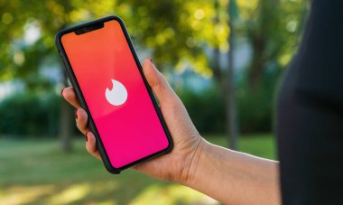 BERLİN, ALMANY AĞUSTOS 2019: oturum açmak için Tinder uygulamasının logosu olan iPhone X 'leri tutan kadın. Tinder, internetteki romantik randevular için çok platformlu insanların yer belirleme uygulaması. Çok ünlüdür..