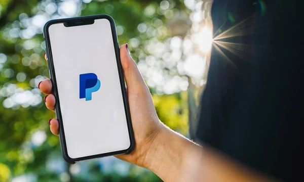 2019年8月 女性手持带有Paypal应用程序标识的Iphone Paypal网站是互联网上一种国际性的资金转移方式 — 图库照片