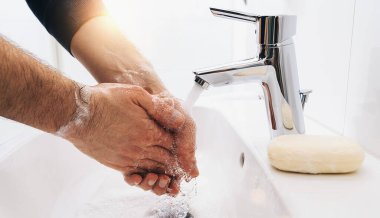 Elleri yıkayan adam lavaboda akan suyla sabunlanıyor, Coronavirus 2019 ncov önleme el hijyeni. Corona Virüsü sık sık ellerini temizleyerek salgın hastalıktan korunuyor..