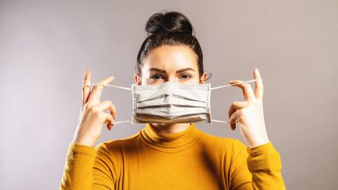Korona COVID-19 ve SARS Cov 2 enfeksiyonundan korunmak için virüs önleyici maske takan kadın.