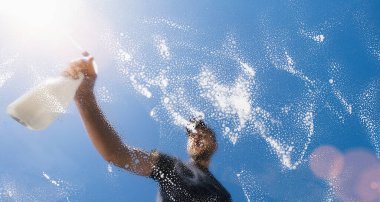 Cam pencereyi sprey şişeyle temizleyen adam - bahar temizliği konsepti