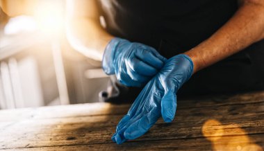 İş yerinde Coronavirus Corona virüsü virüsü kapmasını önlemek için lateks eldiven takan barmen ya da çalışan..
