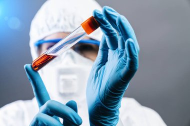 Kadın doktor veya bilim adamı covid 19 ya da Coronavirus 'a karşı icat edilmiş kırmızı aşıyı elinde tutuyor.