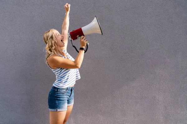 young blond woman shouting on a megaphone. copyspace for your individual text. business concept image